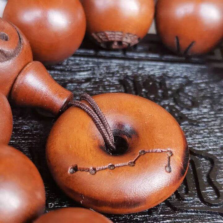 Taoist cultural artifacts featuring a close-up of a wooden prayer bead with intricate detailing.